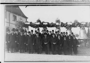 Glockenweihe Bingen; Männergruppe mit Zylinder vor den Glocken auf dem Kirchhof