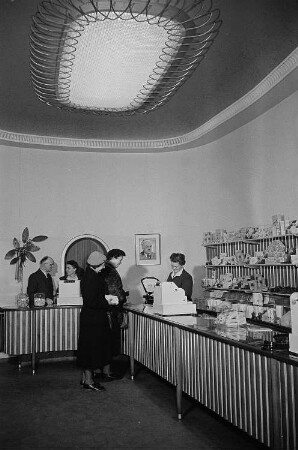 Kundinnen in einem Geschäft für Pralinen und Süßwaren, im Gespräch mit der Verkäuferin