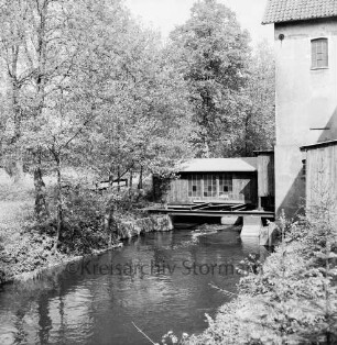 Sühlen: Trave: Wanderweg zwischen Sühlen und Bebensee (Kreis Segeberg): hinten rechts "Zettlersche Mühle" [ehemalige Kupfermühle] mit Nudelfabrik: dahinter Bäume