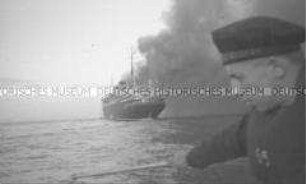 Selbstversenkung des Hochseepassagierdampfers "Columbus" am 19. Dezember 1939, im Vordergrund ein junger Matrose mit Schwimmweste im Rettungsboot