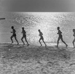 Jugendliche laufen am Strand entlang