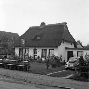 Polizeidienststelle Bargfeld-Stegen: Mittelweg: Reetdachkate mit Vorgarten: links davor Hinweisschild: rechts Auffahrt mit Polizei-VW-Käfer: hinten links Scheune