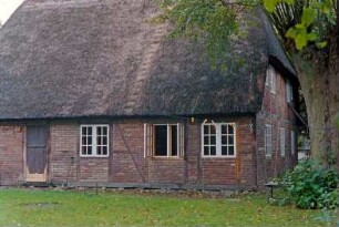 Hoisbüttel: Lübecker Straße 18: giebelständige Fachwerkkate mit Reetdach: Traufseite, Teilansicht Wohntrakt, Stalltür: Giebelseite Wohntrakt: rechts Bäume