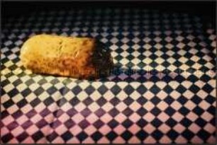 Wurst auf einer blau-weiß-karierten Tischdecke liegend (Altersgruppe 18-21)