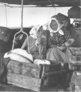 Reisefotos. Zwei Marktfrauen, einen Schuh begutachtend