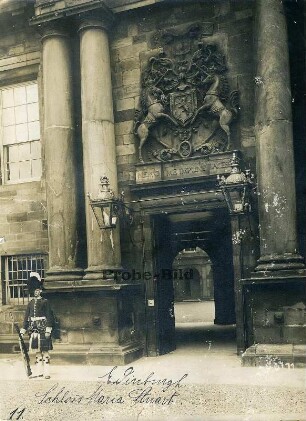 Edinburgh, Schottland. Von einem Gardisten bewachter Eingang des Hoyrood Palace mit Doppelsäulen, Wappenrelief mit Einhörnern und Laternen