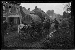 Metz-en-Couture (Dep. Pas-de-Calais, Frankreich): Pferdegespann mit Planwagen auf einer morastigen Ortsstraße (Rückansicht)