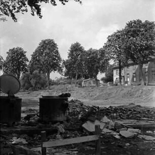 Bürgerpark: Volksküche: Abriss: vorn zwei Kochkessel und Bauschutt: dahinter Ausschachtung für Bau der Stormarnhalle und Bretterstapel: hinten rechts ehemaliges Unfallkrankenhaus und Schuppen