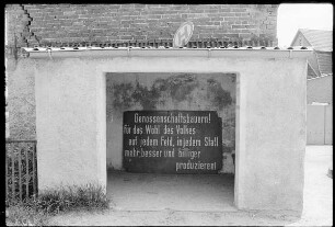 Bushäuschen mit Spruchband "Genossenschaftsbauern! Für das Wohl des Volkes auf jedem Feld, in jedem Stall mehr besser und billiger produzieren!"