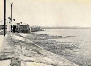 Panama-Stadt (Panama). Drei Touristen stehen auf einer Mauer am Strand und blicken über die Bucht