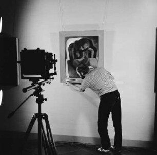 Fotograf der Deutschen Fotothek in der Gemäldegalerie Neue Meister : Der Fotograf der Deutschen Fotothek, Siegfried Bregulla, bei Aufnahmevorbereitungen in der Gemäldegalerie Neue Meister der Staatlichen Kunstsammlungen Dresden. Anbringen eines Grau- und Farbstufenkeils am Gemälde "Mädchen in Rot mit Brief" (H. Strempel, 1948; Gal.-Nr. 2803)