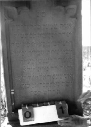 Grabstein 1 (Index: 99797996) Material: Sandstein, weiß Zustand: gut Maße HxBxT: 192x62x20 cm Beschreibung: Stele, eingezogener Rundbogenabschluß mit dreieckigem Aufsatz, getreppter Sockel Symbolik: neogotisch, Maßwerk, Dreipaßbogen: Grabstein 1 (Detailaufnahme)