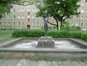 Eisenhüttenstadt: Wohnbebauung Brunnenring (WK I) mit Brunnen (Mädchenfigur)