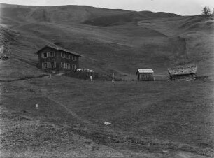 Rosskopfhütte : Ein Tal mit Hütte und kleinen Stallhütten.