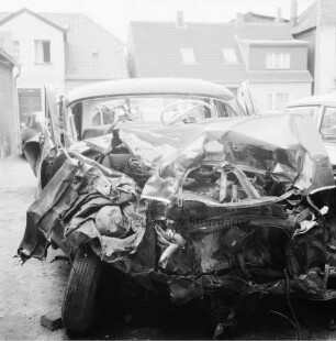 B 404: nach Verkehrsunfall bei Klinken: [Zusammenstoß von zwei Pkws]: schrottreifer Unfall-Pkw auf Abstellplatz: rechts und hinten zwei Autos [angeschnitten]: hinten Häuser