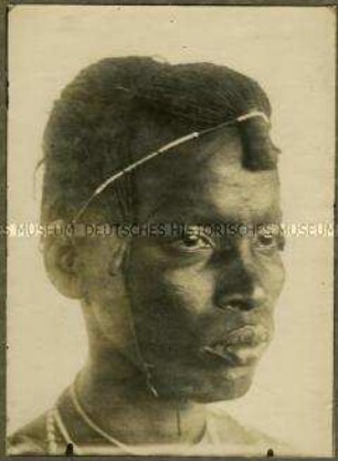 Kopfstudie eines Massai mit traditioneller Haartracht in der Halbfrontalen von rechts