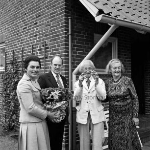 Hermann Claudius: Schriftsteller: geboren 19. Oktober 1878, gestorben 8. September 1980: 100. Geburtstag: vor Wohnhaus: Jubilar mit Ehefrau Gisela Claudius bei Begrüßung der Gratulanten Landesminister für Justiz Henning Schwarz und Ehefrau Gertrud Schwarz, mit Blumenstock: Klappstühle, 19. Oktober 1978