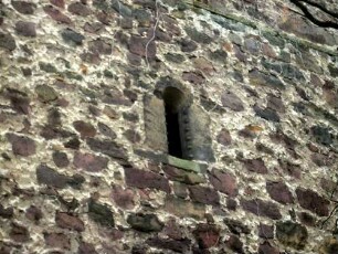 Evangelische Kirche - Kirchturm (spätromanisch gegründet-13 Jhd) von Osten-Mittelgeschoß-Schlitzfenster mit Kugelornamentik am Gewände sowie Werksteinen im Mauersteinverband