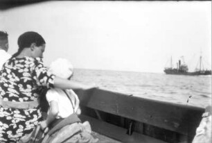 Frau mit kleinem Jungen an Deck eines Schiffes auf dem Meer. Blick zu einem anderen Schiff