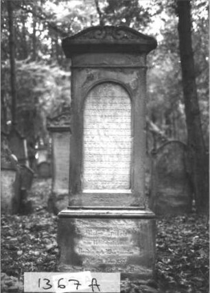 Grabstein 1367 (Index: 99900295) Material: Sandstein Zustand: stark verwittert Maße HxBxT: 163x60x25 cm Beschreibung: aufgesockelte Stele mit Giebelaufsatz mit Voluten Symbolik: Voluten: Grabstein 1367A