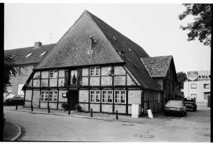 Restaurant Zum Rauchhaus Anno 1756: Bei der Alten Kate: Außenansicht: Fachwerkhaus [ehemalige Ahlemann'sche Kate]: Giebelseite mit Eingangstür und Wirtshausschild, Traufseite mit Zwerchgiebel