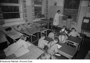 Eine Lehrerin sowie mehrere liegende und sitzende Schüler beim Deutschunterricht im Dr.-Georg-Sacke-Heim