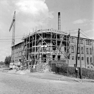 Kayser & Wex: Turmstraße: Büromöbelfabrik: Umbau von Gebäudeteil an Straßenecke: mit Gerüst: Baukran, Trommelmischer, Sandhaufen, Stapel mit Mauersteinen, Leiter: rechts Strommast, Hecke: hinten Schornstein