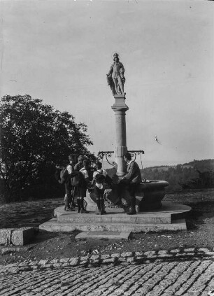 Brunnen : Jungenwandergruppe an einem Brunnen mit Heiligen Figur