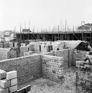 Tannenweg: Wohnungsbau: Rentnerwohnungen: vorn Block mit Grundmauern: dahinter Block mit Baugerüst: im Hintergrund Bäume und Häuser: Winter