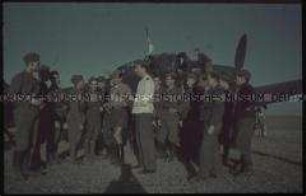 Soldaten vor einem Flugzeug des 4. Sturmkampfgeschwaders 77