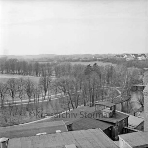 Vogelperspektive: von Silo der Weizenmühle ("Gloria-Mühle") der Johannes Ströh Mühlenwerke am Pferdemarkt: Blick nach Nordwesten: im Vordergrund Betriebsgebäude von Ströh: Traveschleife, Fußgängerbrücke: links Bürgerpark, Exer: hinten Häuser der Straße Am Stadion