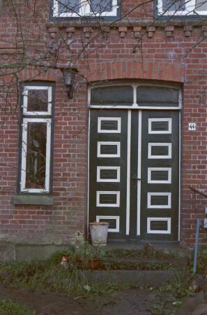 Steinfeld 44: traufständiges Wohnhaus aus Backstein: Straßenfront, Teilansicht: Eingangstür mit Oberlicht, daneben Fenster, Hausnummer