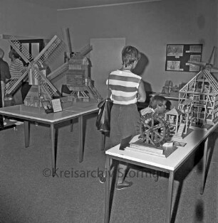 Ausstellung: Rathaus und Bürgerhaus Glinde [später Marcellin-Verbe-Haus]: Heimatverein Glinde: Mühlenmodelle auf Tischen: dazwischen Kinder und Erwachsene als Besucher