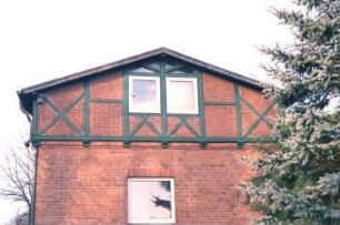 Schulstraße 12: Alte Schule: giebelständiger Backsteinbau: Querflügel, Giebelseite, oben Fachwerk