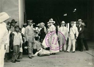 Manila (Philippinen), Hafen. Touristengruppe nach der Ankunft eines Hochseepassagierdampfers der Hapag, einheimische Kinder und einheimischer Uniformierter am Eingang der Halle von Pier 5