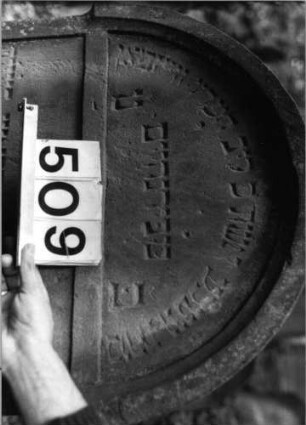 Grabstein 509 (Index: 99803848) Material: Sandstein Zustand: kleinere Teile unten abgeblättert Maße HxBxT: 112x60x11 cm Beschreibung: Stele mit verdachtem Rundbogen, profilierter Rand, Giebelfeld Besonderheit: längerer Text: Grabstein 509 (Detailaufnahme 1)