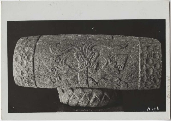 "Ancient stone replica of a teponaztli (wooden drum) resting on a bast curl with a relief depicting the god of play and dance (flower god) Macuilxochitl. Guillermo de Heredia Collection.