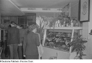 Besucher an einem Messestand mit Lebensmitteln (Wurst- und Fleischwaren)