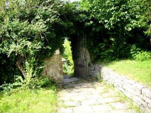 Kirchhof im Westen mit Kirchhofmauer (stark überwuchert) in Mauerstärke mit Mannpforte
