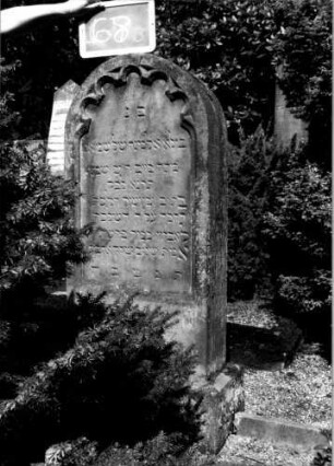 Grabstein 68 (Index: 100109959) Material: Sandstein Zustand: leicht verwittert Maße HxBxT: 132x53x20 cm Beschreibung: Stele, Sockel, Rundbogenabschluß, Schriftfeld eingetieft mit Rundbogenfries Symbolik: Rundbogenfries: Grabstein 68