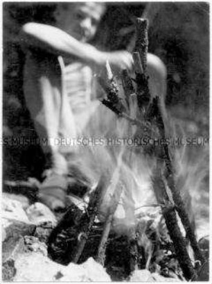 Junge hinter Lagerfeuer