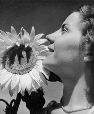 Sonnenblumen. Junge Frau im Profil vor Sonnenblume