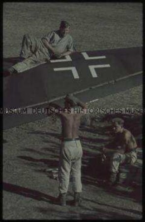 Soldaten auf und am Tragflügel eines Flugzeugs