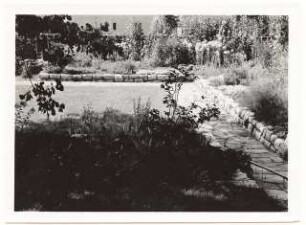 Garten Hügelmann, Berlin-Kaulsdorf: Plattenweg und mit Steinen eingefasste Blumenbeete