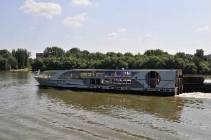 Ungarisches Donauufer bei Budapest - Schiffsrohbau : Das ungarische Donauufer zwischen Esztergom und Budapest, fotografiert am 13. Juni 2011 von Bord eines stromabwärts fahrenden Donauschiffes aufgenommen. Der Rohbau eines Kreuzfahrtschiffes wird stromaufwärts geschleppt