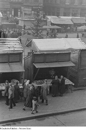 Stände und Besucher auf dem Weihnachtsmarkt sowie Häuser der Westseite des Marktplatzes