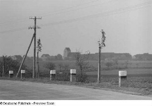 Landstraße mit einem Blick auf ein Dorf