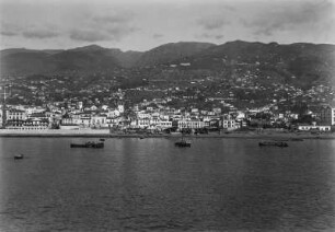 Brasilianische Küste : Häuser einer Stadt auf Hängen gelegen an der brasilianischen Küste. Im Vordergrund Schiffe auf dem Atlantischen Ozean.