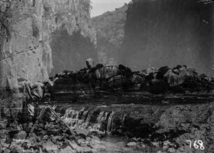 Expeditionsteilnehmer mit Kamera : Im Vordergrund ein Expeditionsteilnehmer mit einer Kamera auf felsigem Untergrund. Das Foto ist doppelt belichtet.
