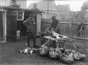 Jäger mit erlegten Tieren